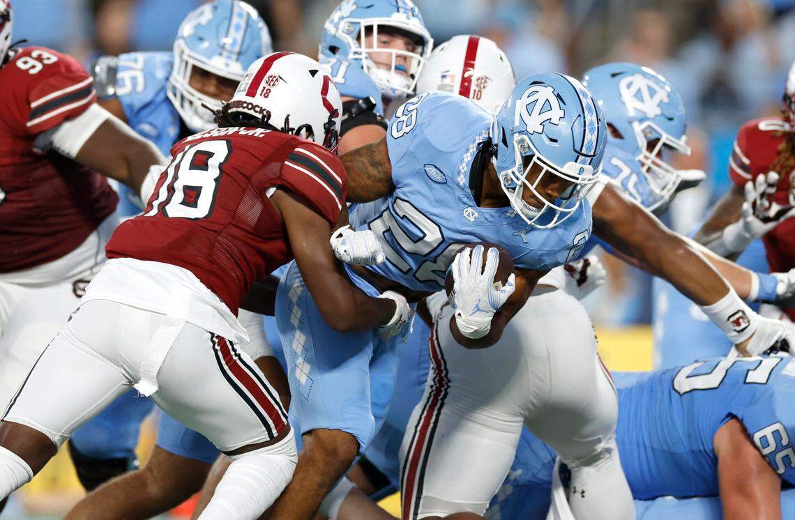 North Carolina running back Omarion Hampton (28) gains yards as South Carolina defensive back Keenan Nelson Jr. (18) tries to slow him down during the first half of UNC’s game against South Carolina in the Duke’s Mayo Classic at Bank of America Stadium in Charlotte, N.C., Saturday, Sept. 2, 2023.