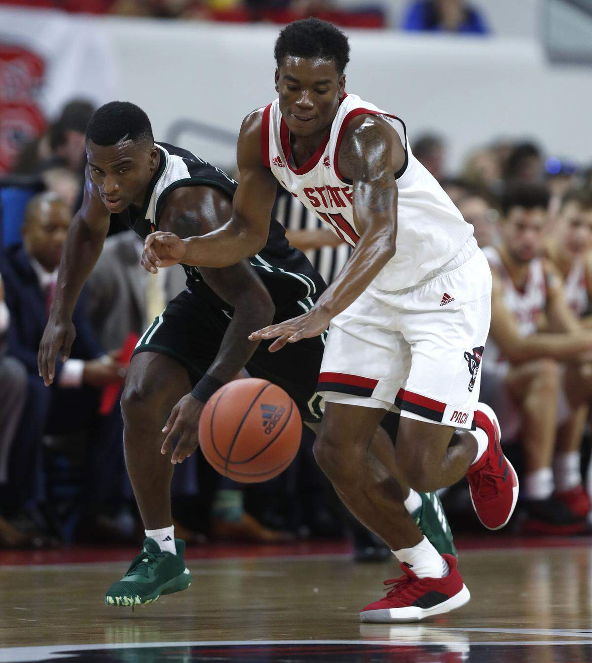 N.C. State’s Markell Johnson (11) steals the ball from Mount Olive’s Michael Brown (10) during the first half of N.C. State’s exhibition game against Mount Olive at PNC Arena in Raleigh, N.C., Sunday, Oct. 27, 2019.
