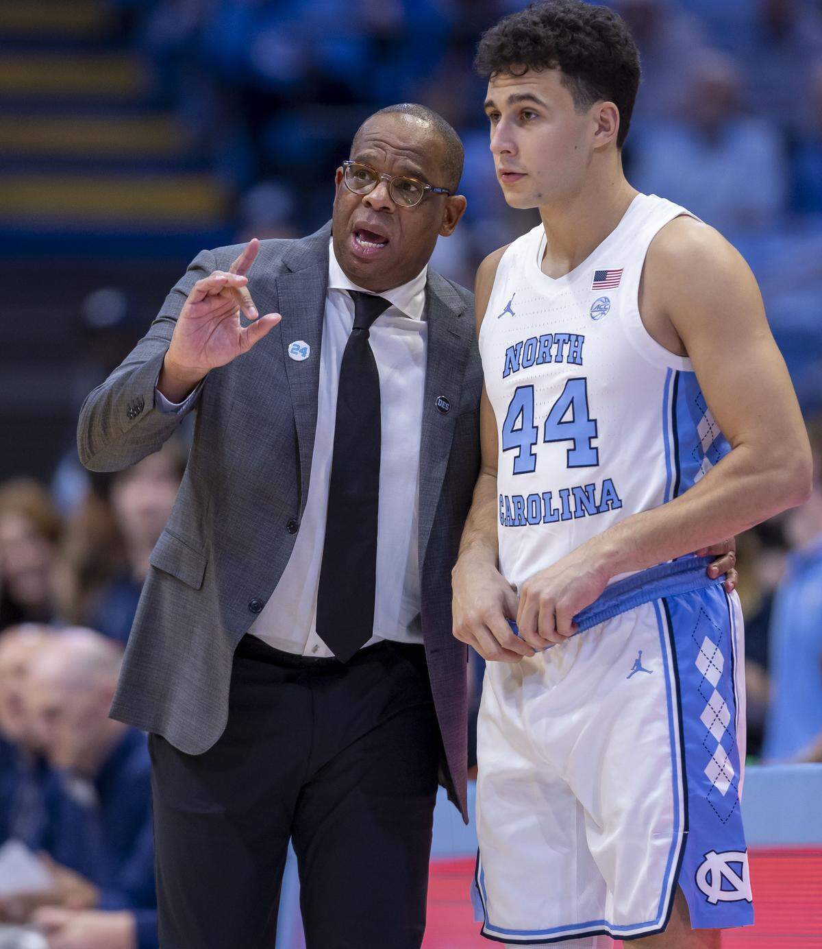 North Carolina coach Hubert Davis has a word with Luka Bogavac (44) before inserting him into the game on Monday, November 3, 2025 at the Smith Center in Chapel Hill, N.C.