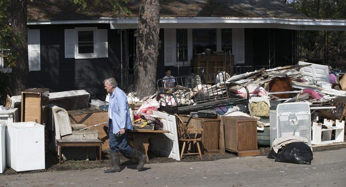 In this Sept. 2018 file photo Bob Adams walks past the discarded belonging of his mother’s home in Trenton, N.C. The home located next to the Trent River had more than five feet of water in the kitchen at the height of flooding from Hurricane Florence. Adams’ mother Bertha Adams evacuated to Elizabeth City during the storm.