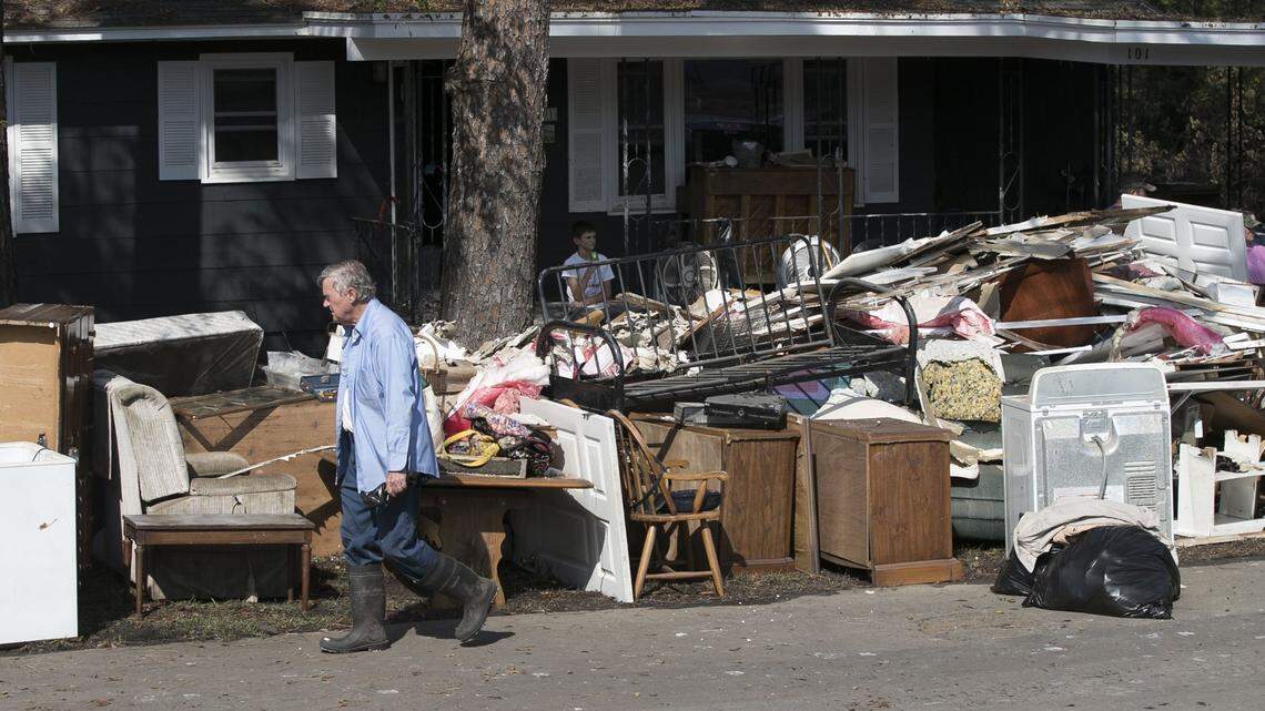 In this September 2018 file photo, Bob Adams walks past the discarded belonging of his mother’s home in Trenton, N.C. The home located next to the Trent River had more than five feet of water in the kitchen at the height of flooding from Hurricane Florence. Adams’ mother Bertha Adams evacuated to Elizabeth City during the storm.