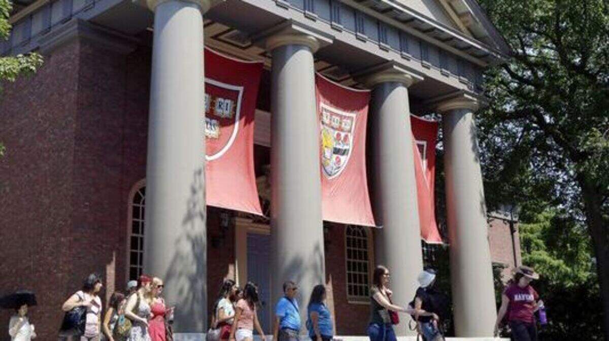 A tour group walks through the campus of Harvard University in Cambridge, Mass. (AP photo)