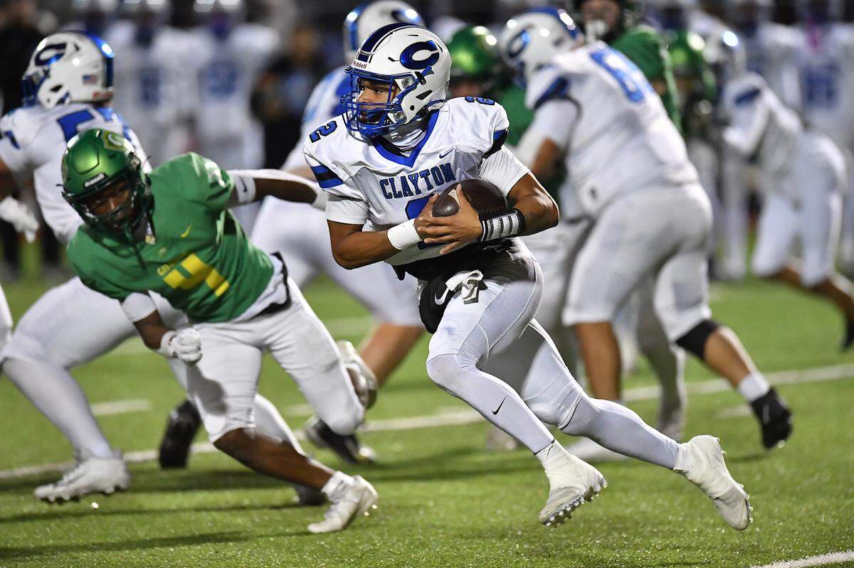 Clayton quarterback Aiden Smalls (2) rushes for yards against Cardinal Gibbons during the first half. The Clayton Comets and the Cardinal Gibbons Crusaders met in the East Regional Final of the NCHSAA 7A Football Championship in Clayton, N.C. on December 4, 2025.