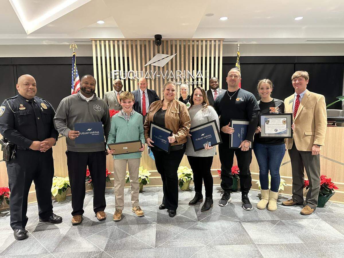 The Fuquay-Varina Board of Commissioners honored four Fuquay-Varina Middle School staff members and a student on Dec. 20, 2022 for their role in responding to a student who fired a gun inside a classroom. Pictured from left to right are Police Chief Brandon Medina, principal Kris Clark, 8th-grade student Colton Kaplar, assistant principal Paige Elliott, sixth-grade teacher Lynn Guilliams, sixth-grade teacher Jeff Junio, sixth-grade teacher Samantha Colecchia and Mayor Blake Massengill.