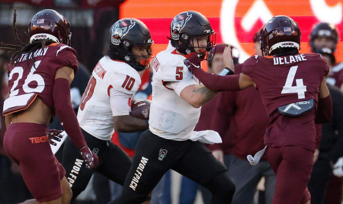N.C. State quarterback Brennan Armstrong (5) blocks Virginia Tech cornerback Mansoor Delane (4) as KC Concepcion (10) runs for yards during the first half of N.C. State’s game against Virginia Tech at Lane Stadium in Blacksburg, VA, Saturday, Nov. 18, 2023.