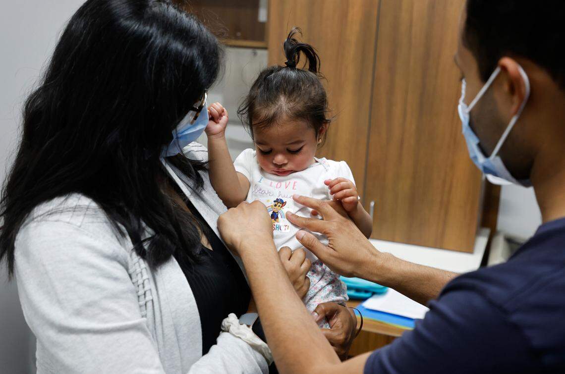 Sanket Dalal of Cary puts a ‘I got the shot’ sticker on his one-year-old daughter Nilani after she received the Moderna COVID-19 vaccine at UNC Family Medicine & Pediatrics at Panther Creek in Cary, N.C., on Friday, June 24, 2022. Holding Nilani is her mother, Nikita.