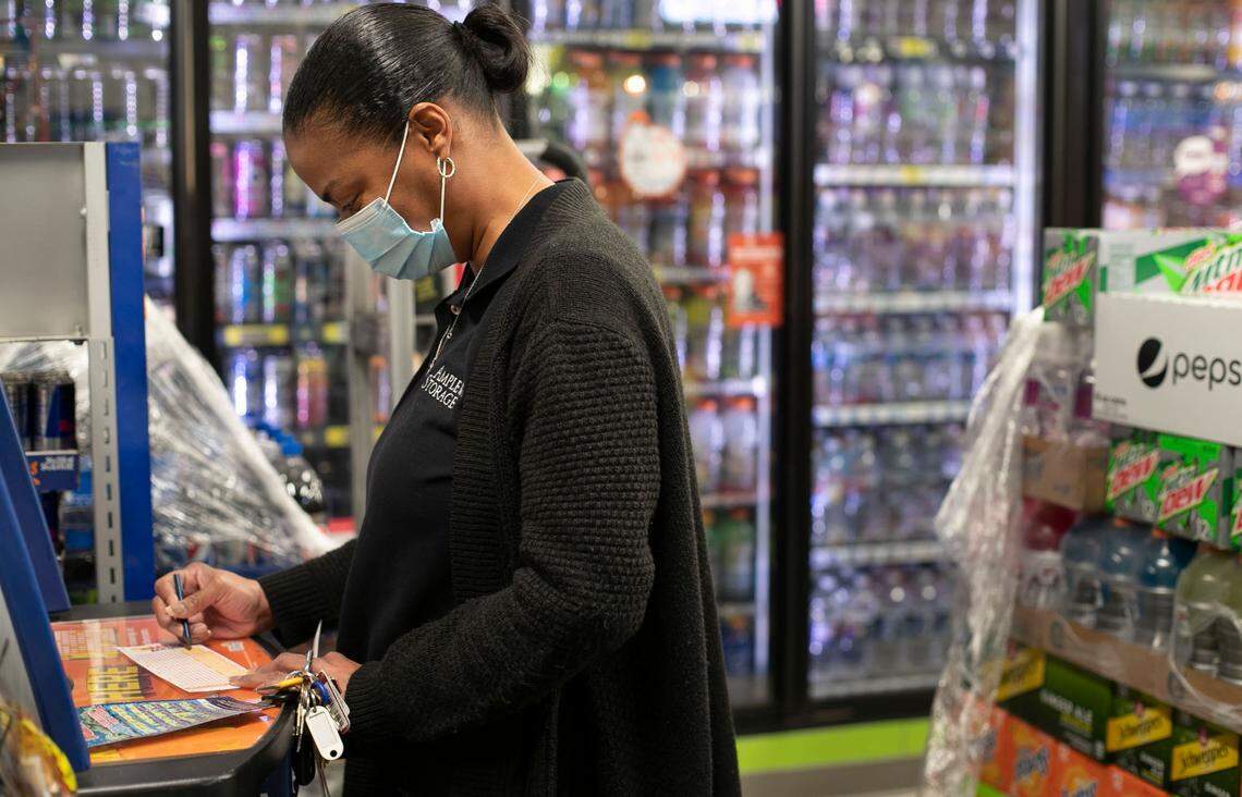 Taniesha Walker plays the Mega Millions lottery at Eagles Express convenience store Thursday, January 21, 2021 in Knightdale, NC. The jackpot is $970 million and growing with the next drawing on Friday, January 22, 2021.