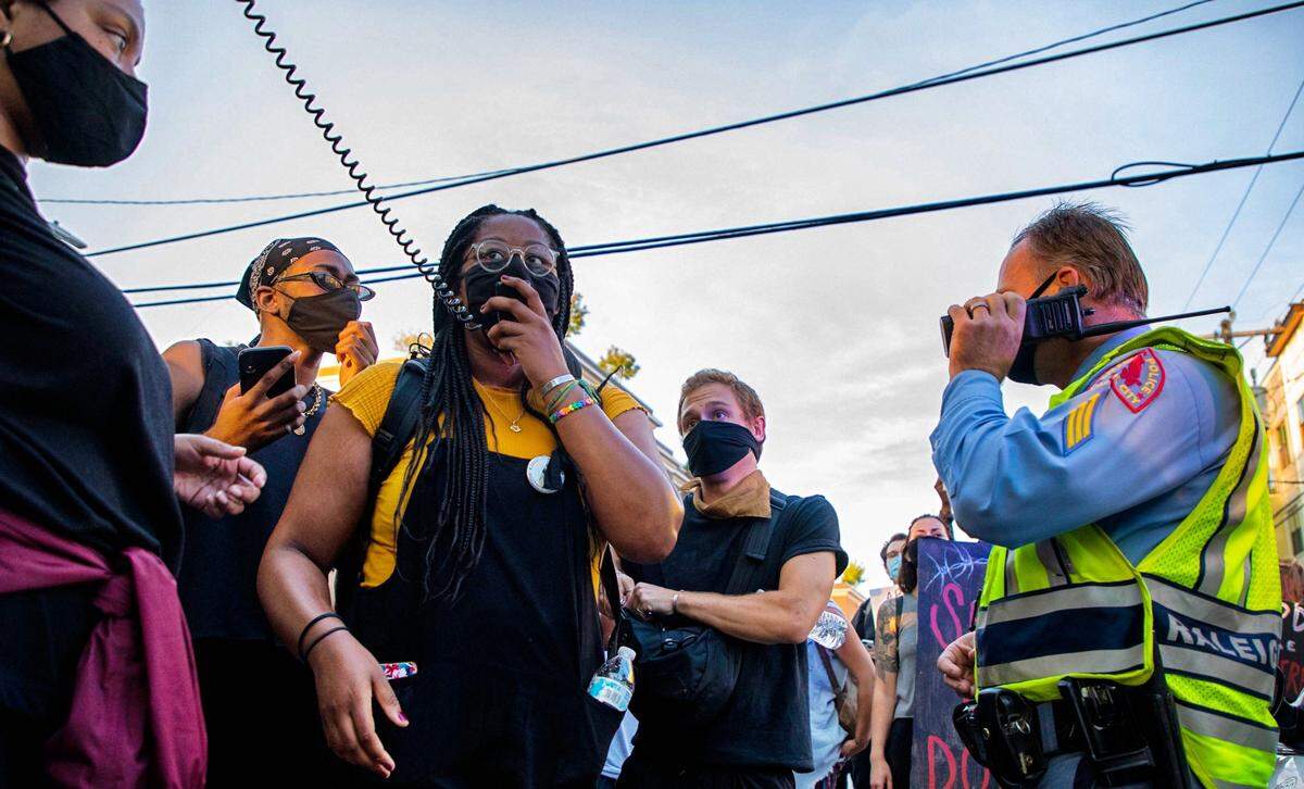 Victoria Smith, co-founder of the Wake County Black Student Coalition, leads chants while surrounding a Raleigh police officer during a protest held in solidarity for Black Lives Matter demonstrations this week in Gastonia, N.C., Roxboro, N.C., and Portland, Oregon, on Wednesday, July 29, 2020, in Raleigh, N.C.