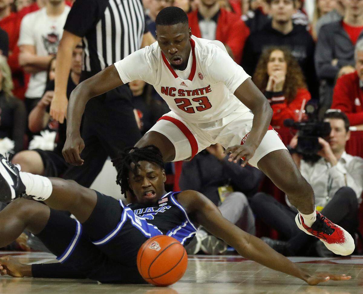 Duke’s Mark Mitchell and N.C. State’s Mohamed Diarra dive on the floor during the first half of the Blue Devils’ game on Monday, March 4, 2024, at PNC Arena in Raleigh, N.C.