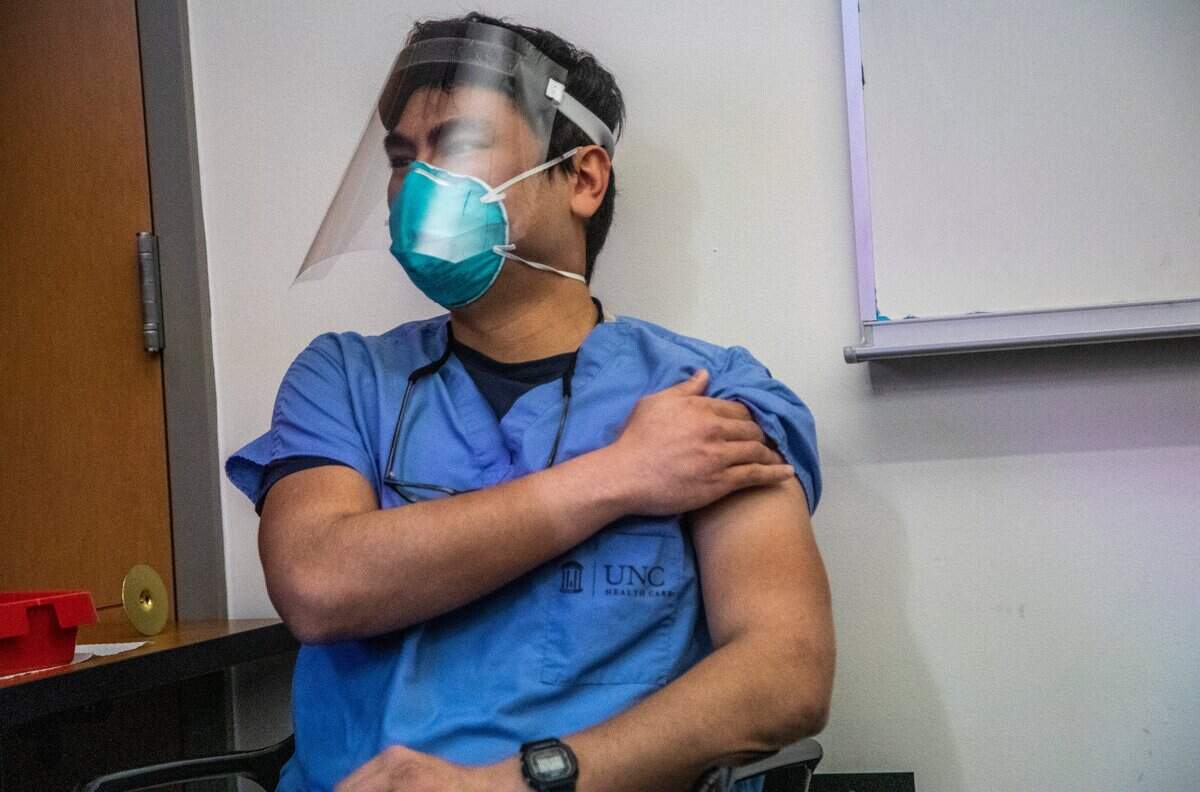 Dr. Aidin Ashoori holds his arm after receiving his first dose of COVID-19 vaccine at UNC Health in Chapel Hill on Dec. 17, 2020.
