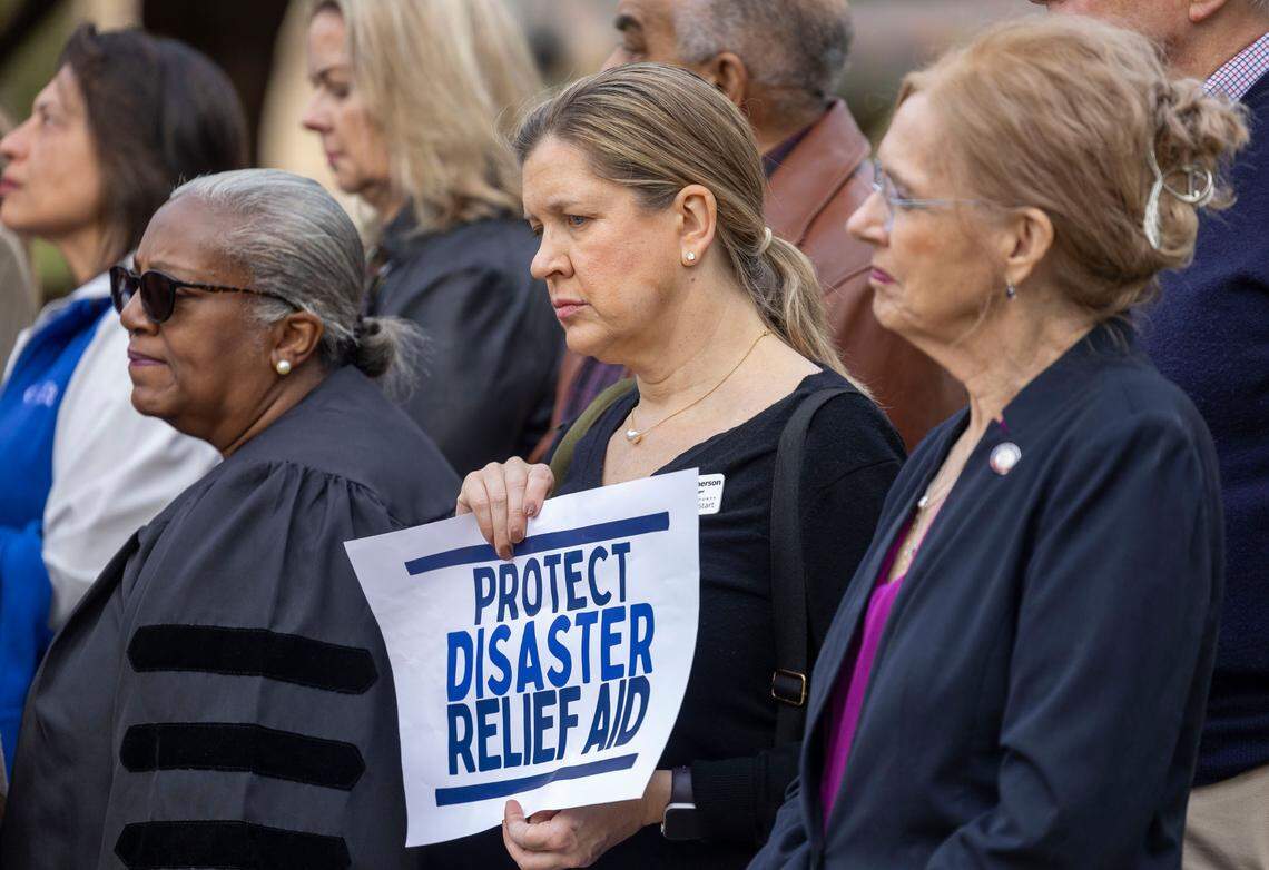 Jennifer MacPherson, center, with Wake County Smart Start, listens to N.C. Attorney General Jeff Jackson during a press briefing on the freezing of federal funds by President Donald Trump, on Friday, January 31, 2025 in Raleigh, N.C.