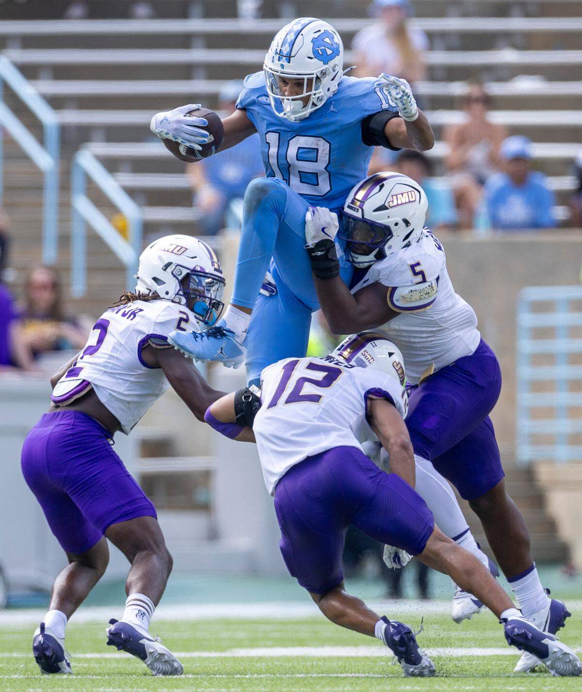 North Carolina tight end Bryson Nesbitt (18) hurdles over James Madison safety Kyle Holmes (12) after a 12-yard pass completion from quarterback Jacolby Criswell in the fourth quarter on Saturday, September 21, 2024 at Kenan Stadium in Chapel Hill, N.C.