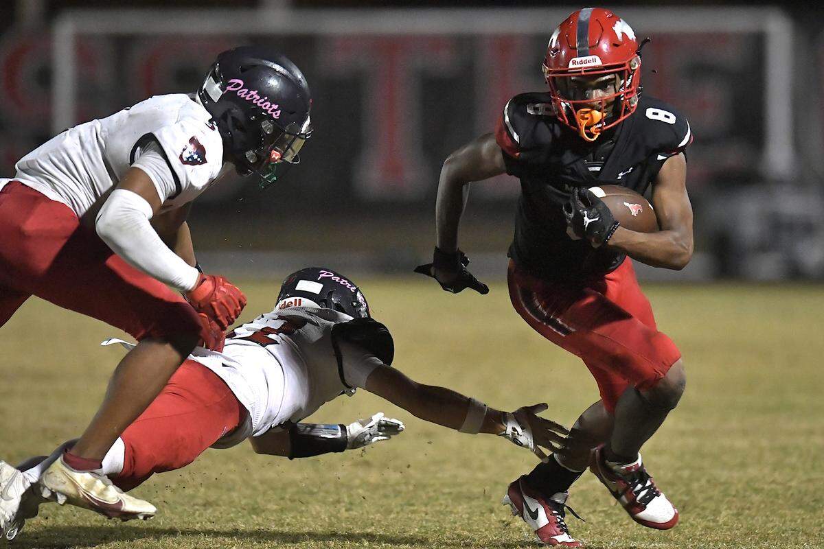 Middle Creek’s Malachi Biggs (8) rushes for yardage against Apex Friendship’s Sam Clodfelter (2) and Adam Schreiber (12) during the fourth quarter. The Middle Creek Mustangs and the Apex Friendship Patriots met in a football game in Cary, N.C. on October 25, 2024.