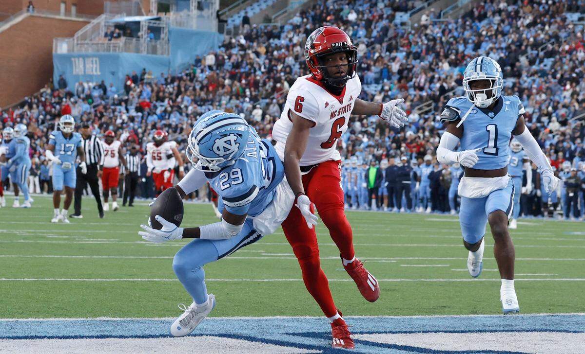 North Carolina defensive back Marcus Allen (29) intercepts the ball intended for N.C. State wide receiver Wesley Grimes (6) during the first half of N.C. State’s game against UNC at Kenan Stadium in Chapel Hill, N.C., Saturday, Nov. 30, 2024.