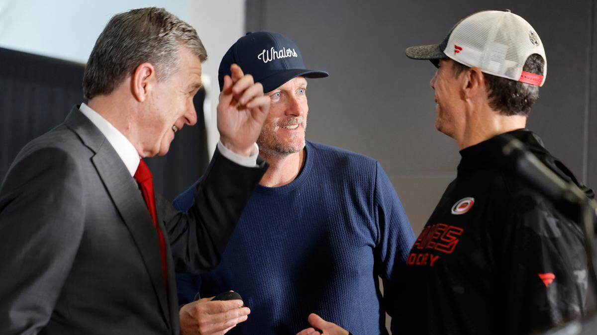 Gov. Roy Cooper (from left), Hurricanes owner Tom Dundon and Hurricanes coach Rod Brind’Amour talk before a ceremony celebrating the newly renamed Lenovo Center in Raleigh, N.C., Thursday, Sept. 19, 2024.