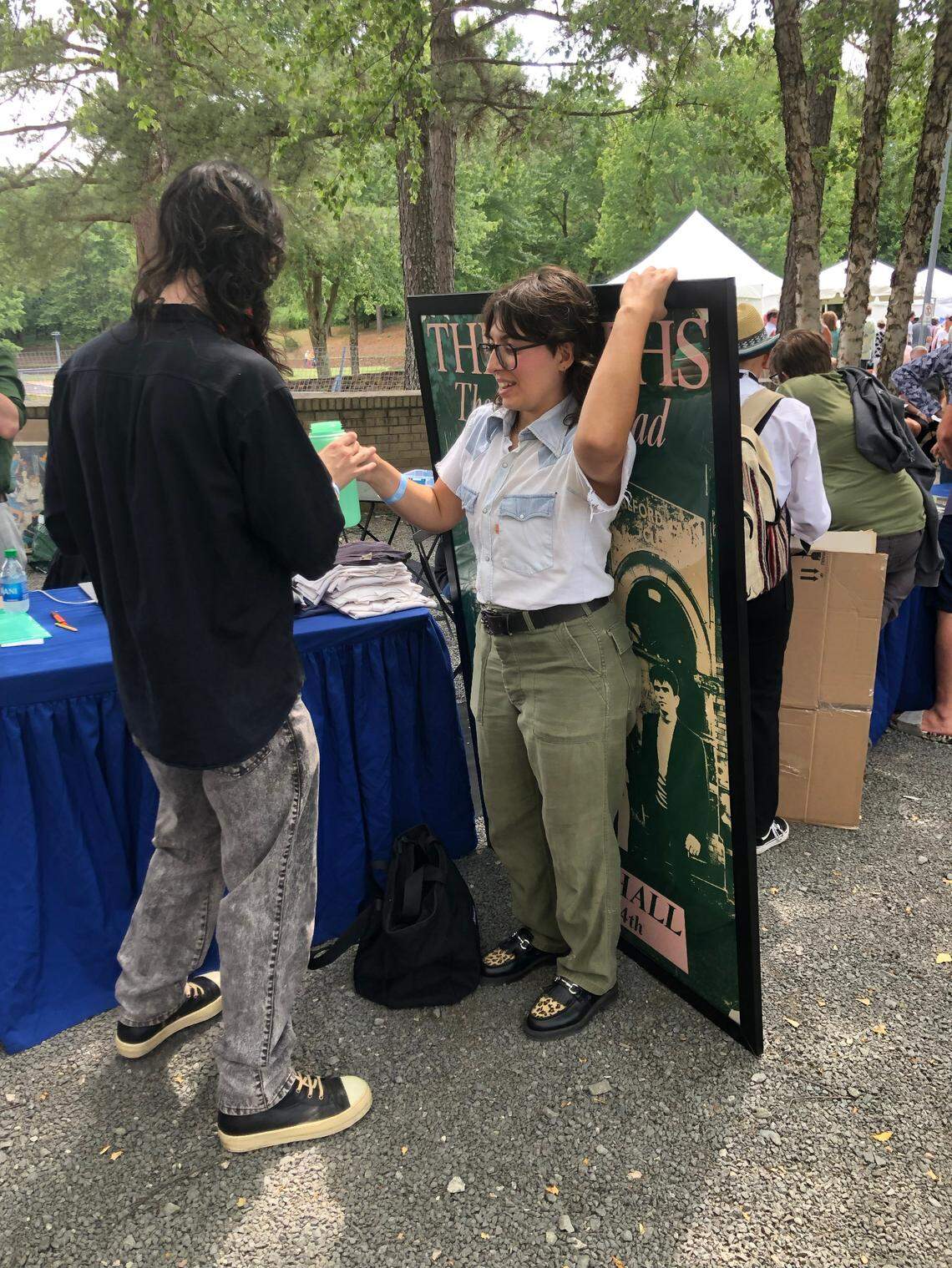 A visitor to the Raleigh, NC taping of “Antiques Roadshow” with a concert poster from The Smiths show in London.