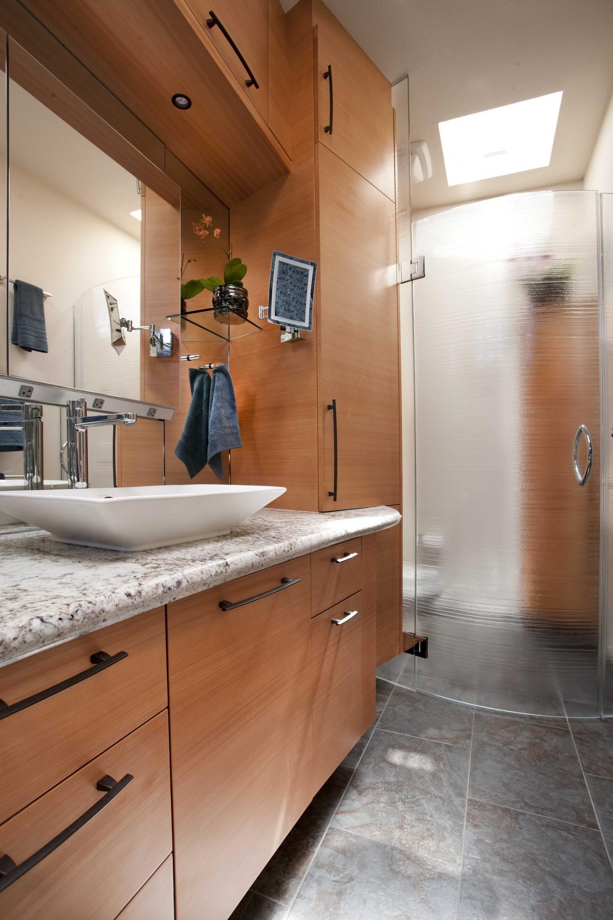 Packed with needed storage, this long rectangular bath is softened by sensuous curves. Plumbing fixtures and hardware add an Asian influence.