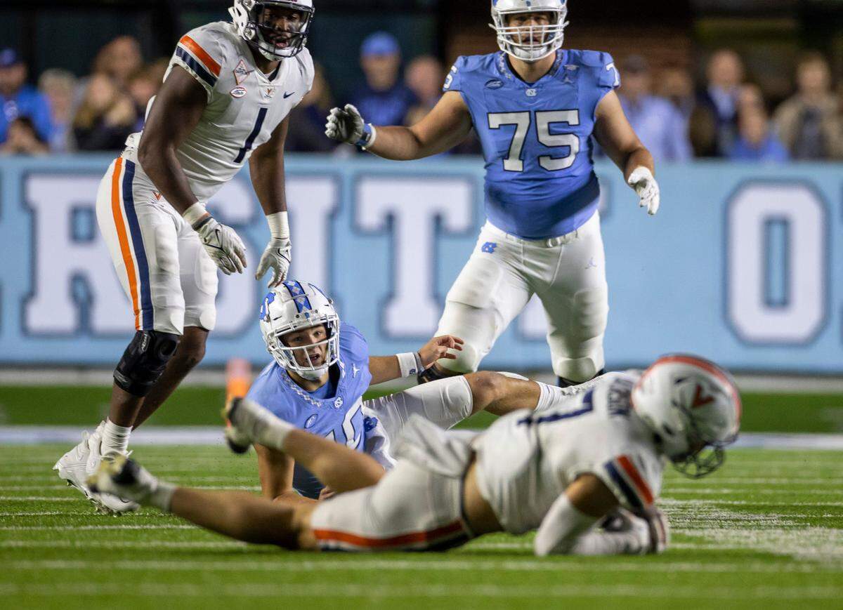 North Carolina quarterback Drake Maye (10) watches as Virginia’s James Jackson (7) intercepts the ball after Maye was hit while throwing with 26 seconds to play in the game, securing a 31-27 Virginia victory on Saturday, October 21, 2023 at Kenan Stadium in Chapel Hill, N.C.