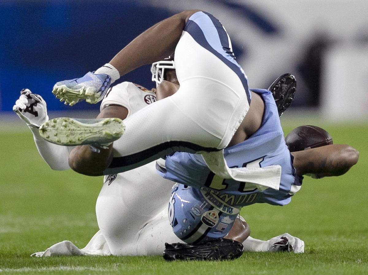 North Carolina’s Josh Downs (11) is stopped by Texas A&M’s Jaylon Jones (17) on third down setting up the Tar Heels’ first field goal in the first quarter in the Capital One Orange Bowl on Saturday, January 2, 2021in Miami Gardens, Florida. 