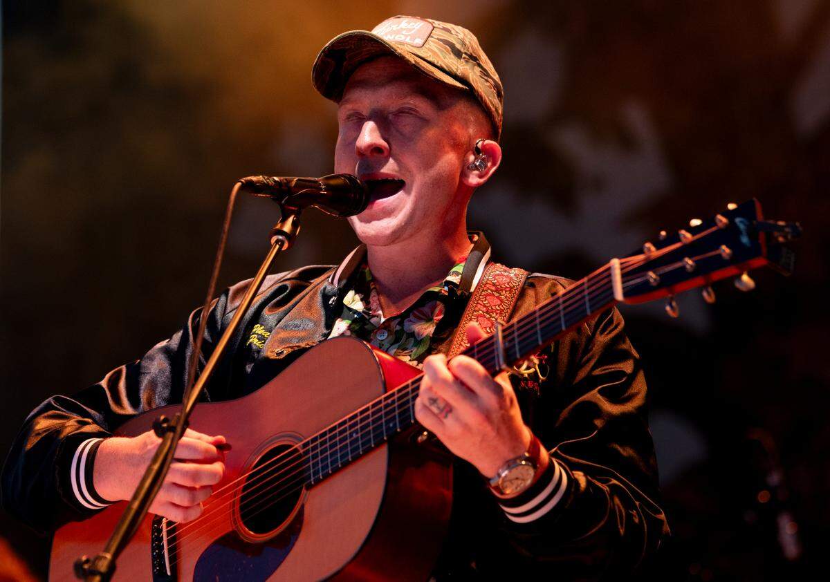 Tyler Childers takes the stage wearing a jacket on a hot night at Raleigh, N.C.’s Red Hat Amphitheater Sunday night, Aug. 13, 2023.