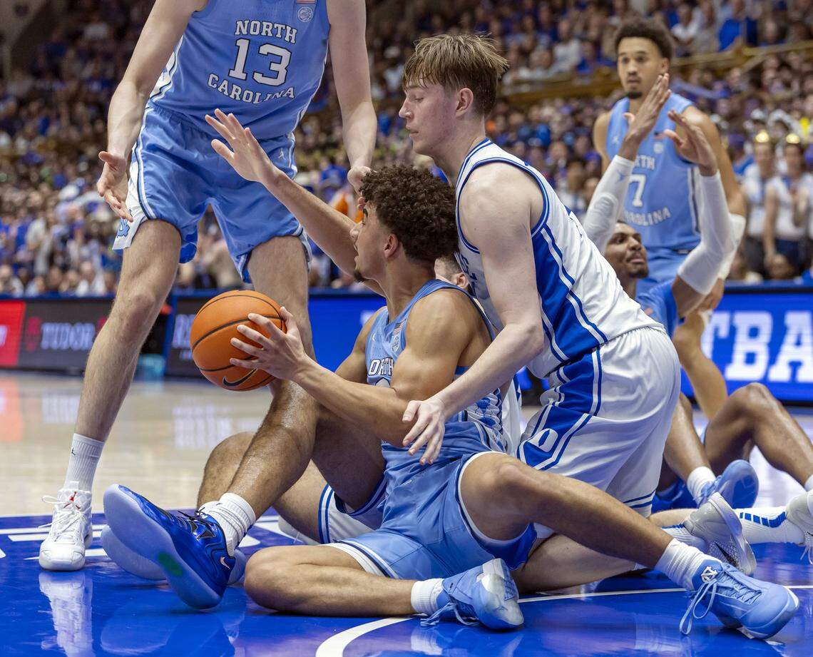 North Carolina guard Derek Dixon (3) and Duke guard Nikolas Khamenia (14) battle for a loose ball under the Blue Devils’ basket in the first half on Saturday, March 7, 2026 at Cameron Indoor Stadium in Durham, N.C.