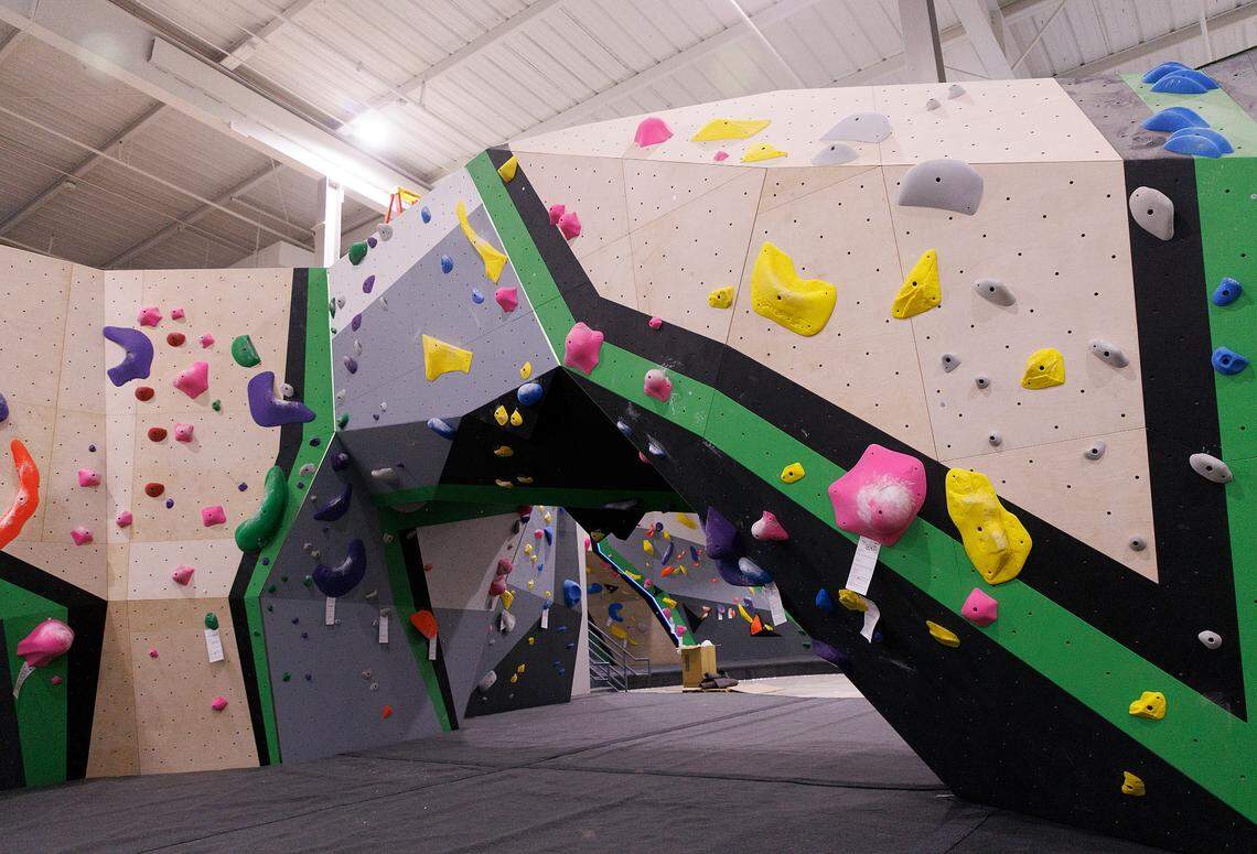 Triangle Rock Club’s Salvage Yard location, photographed in Raleigh, N.C. on Friday, Sept. 27, 2024, includes bouldering walls where climbers can follow routes with climbing holds that are color-coded for difficulty.