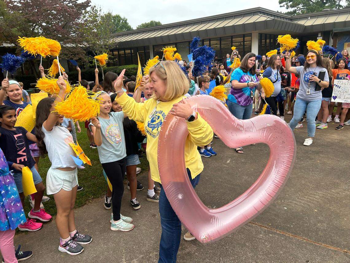 Winston Pierce gives high-fives at Farmington Woods Elementary School in Cary, N.C., on Oct. 6, 2023 during a celebration for her being named Wake County’s 2023-24 Principal of the Year.