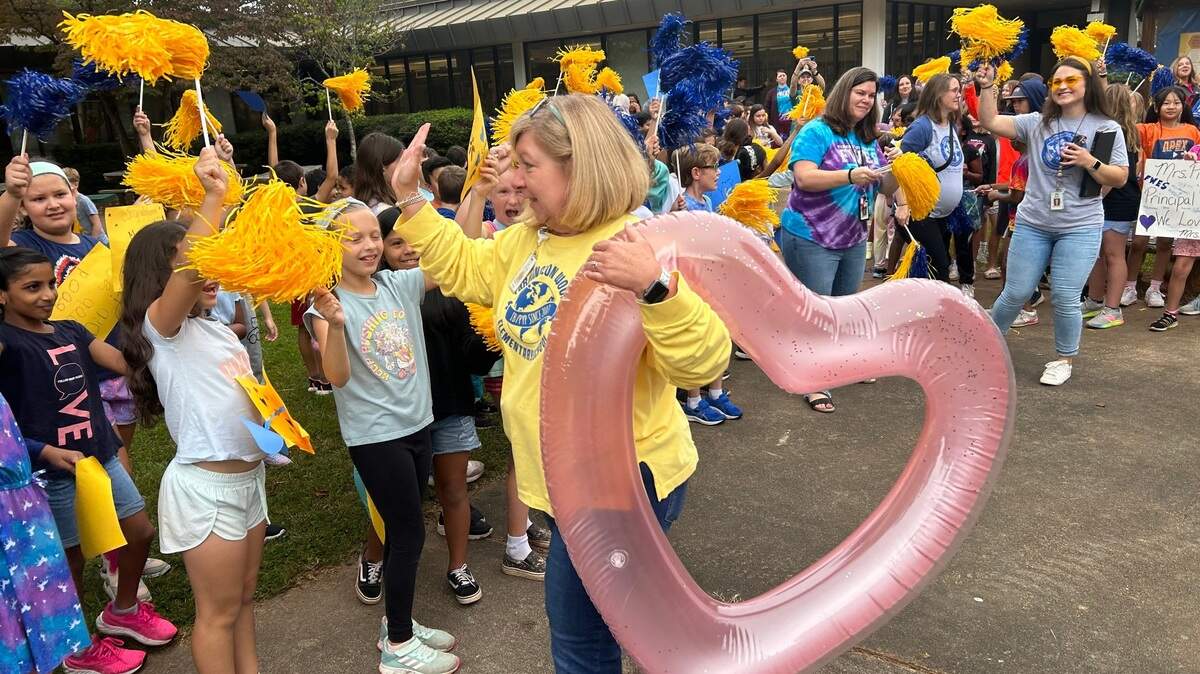 Winston Pierce gives high-fives at Farmington Woods Elementary School in Cary, N.C., on Oct. 6, 2023 during a celebration for her being named Wake County’s 2023-24 Principal of the Year.