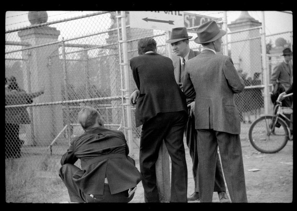 Men who couldn’t get a ticket to the sold-out Duke-Carolina football game in 1939 congregate around a gate to try to get a view of the rivalry game.