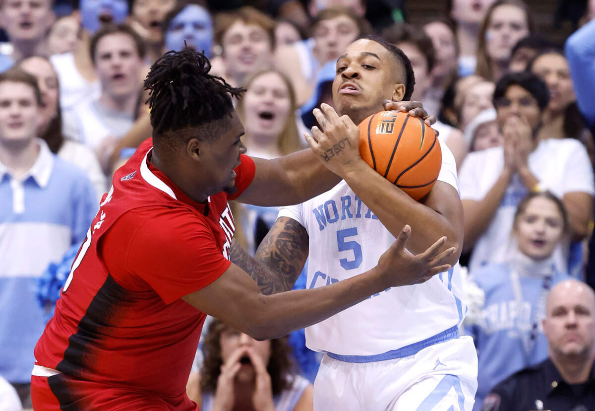North Carolina’s Armando Bacot (5) steals the ball from N.C. State’s D.J. Burns Jr. (30) during the first half of N.C. State’s game against UNC at the Smith Center in Chapel Hill, N.C., Saturday, Jan. 21, 2023.