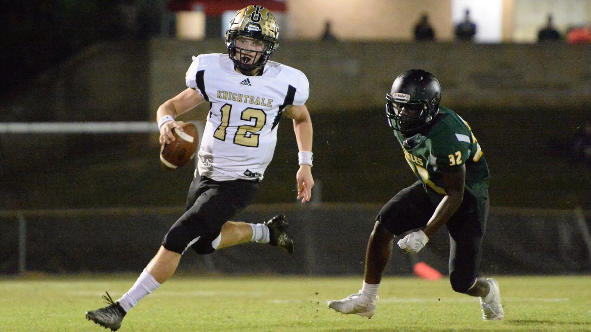 Dax Hardy (12) of Knightdale looks for a pass against pressure from Carmelo Merritt (32) of Enloe. The Knightdale Knights visited the Enloe Eagles in a high school football game on September 20, 2019.