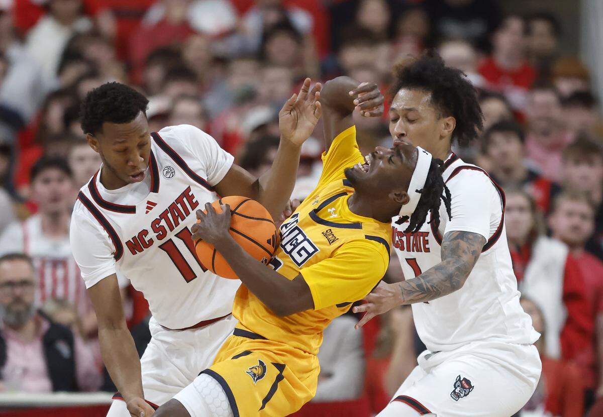 N.C. State’s Quadir Copeland and Darrion Williams pressure UNC Greensboro’s Donald Whitehead, Jr. during the first half of the Wolfpack’s game on Wednesday, Nov. 12, 2025, at Lenovo Center in Raleigh, N.C.