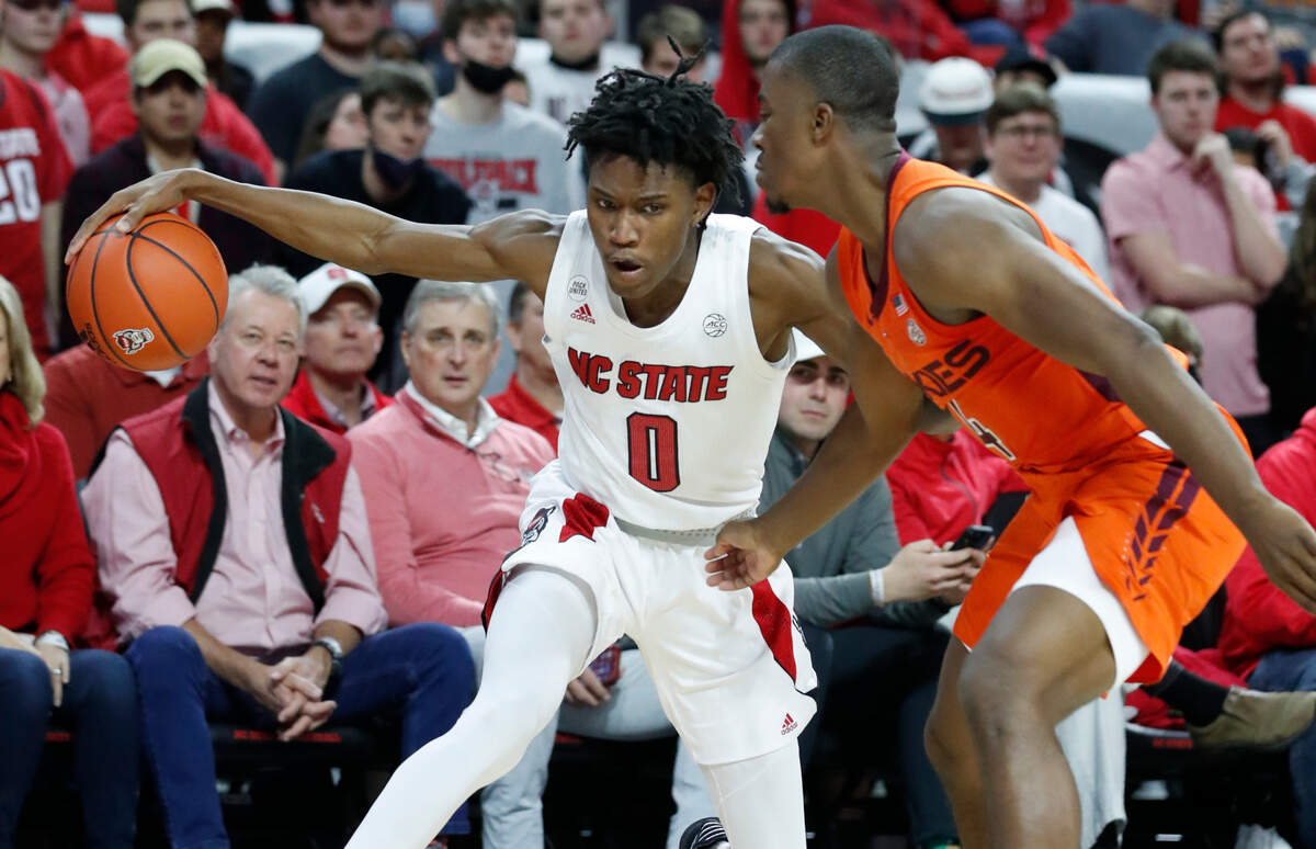 N.C. State’s Terquavion Smith (0) looks to get around Virginia Tech’s Nahiem Alleyne (4) during the second half of Virginia Tech’s 62-59 victory over N.C. State at PNC Arena in Raleigh, N.C., Wednesday, Jan. 19, 2022.
