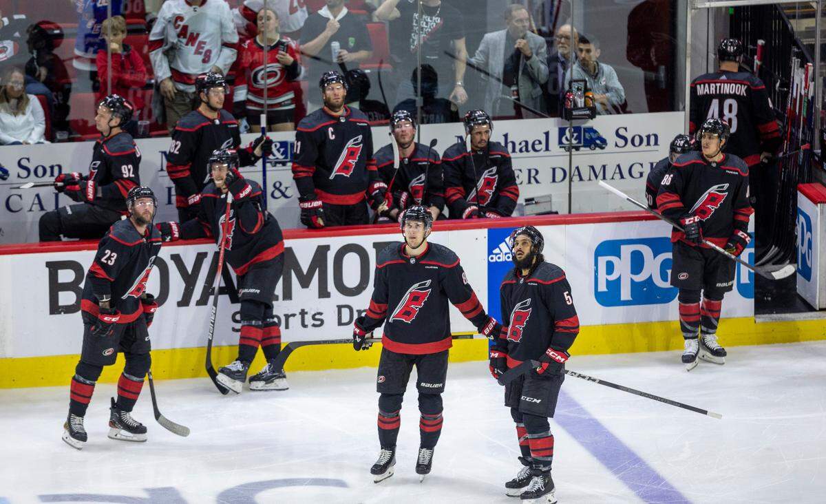 Carolina Hurricanes center Martin Necas (88) and defenseman Jalen Chatfield (5) watch the video replay of the game winning goal in overtime by New York Rangers left wing Artemi Panarin (10), securing their 3-2 victory in Game 3 during the second round of the 2024 Stanley Cup playoffs on Thursday, May 9, 2024 at PNC Arena, in Raleigh N.C.