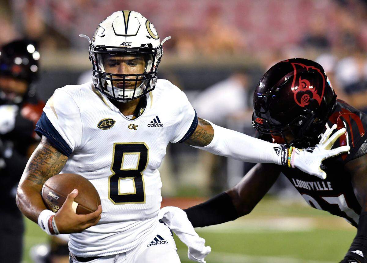 In this Oct. 5, 2018, file photo, Georgia Tech quarterback Tobias Oliver (8) tries to fend off Louisville linebacker Nick Okeke (97) during the second half of an NCAA college football game in Louisville, Ky.
