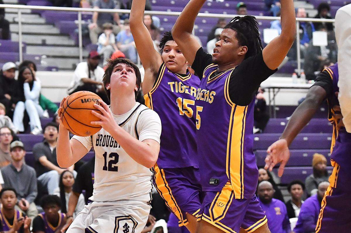 Broughton's Austin Youngs (12) looks to shoot against Wilson's Jaden Gerald (5) and Carmello Whitaker (15) during the first half. The Broughton Capitals and the Wilson (SC) Tigers played in the first round of the John Wall Holiday Tournament on December 26, 2025.