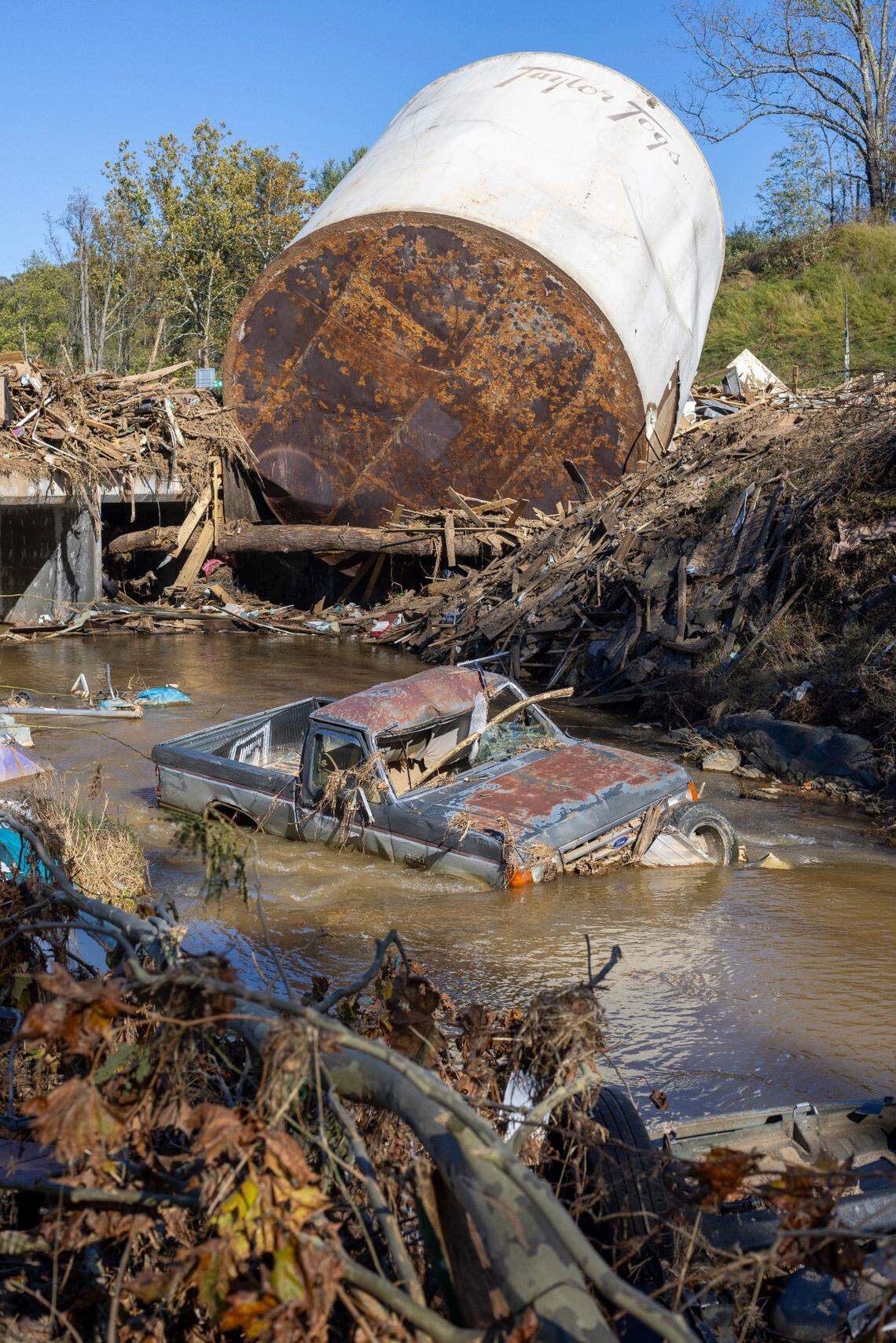 Little Crabtree Creek is littered with storm debris and vehicles, on Thursday, October 17, 2024, three weeks after Hurricane Helene flooded the South Toe River and adjacent creeks near Micaville in Yancey County, N.C.