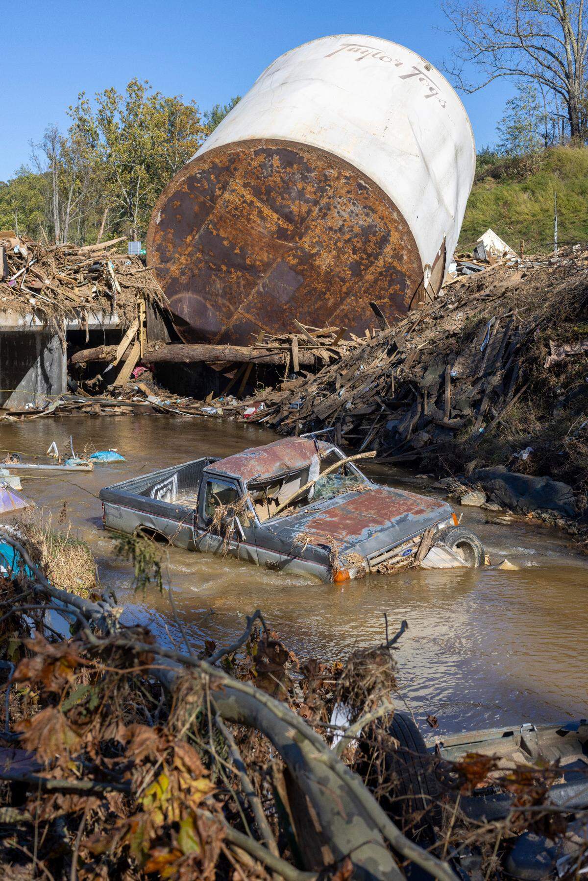 Little Crabtree Creek is littered with storm debris and vehicles, on Thursday, October 17, 2024, three weeks after Hurricane Helene flooded the South Toe River and adjacent creeks near Micaville in Yancey County, N.C.