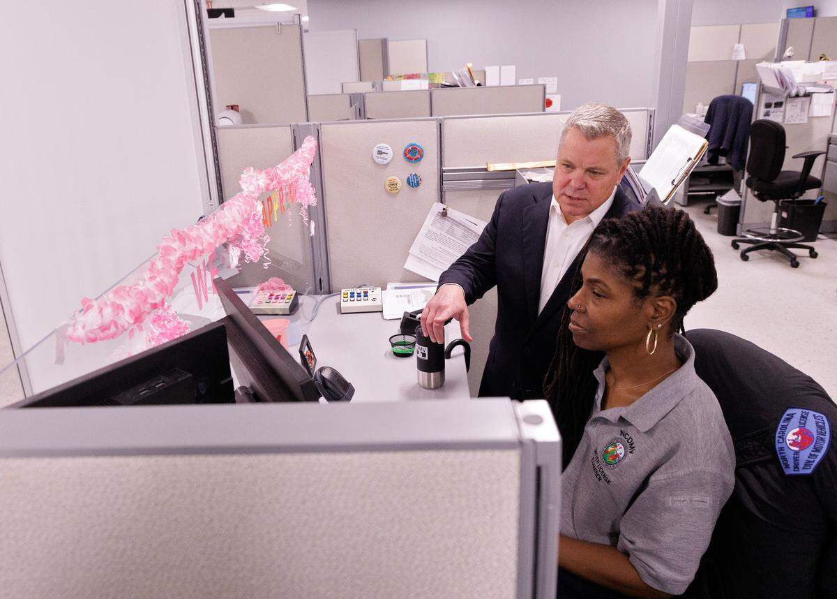 DMV Commissioner Paul Tine talks with LaKishia Bell, a driver’s license examiner at the East Raleigh office.