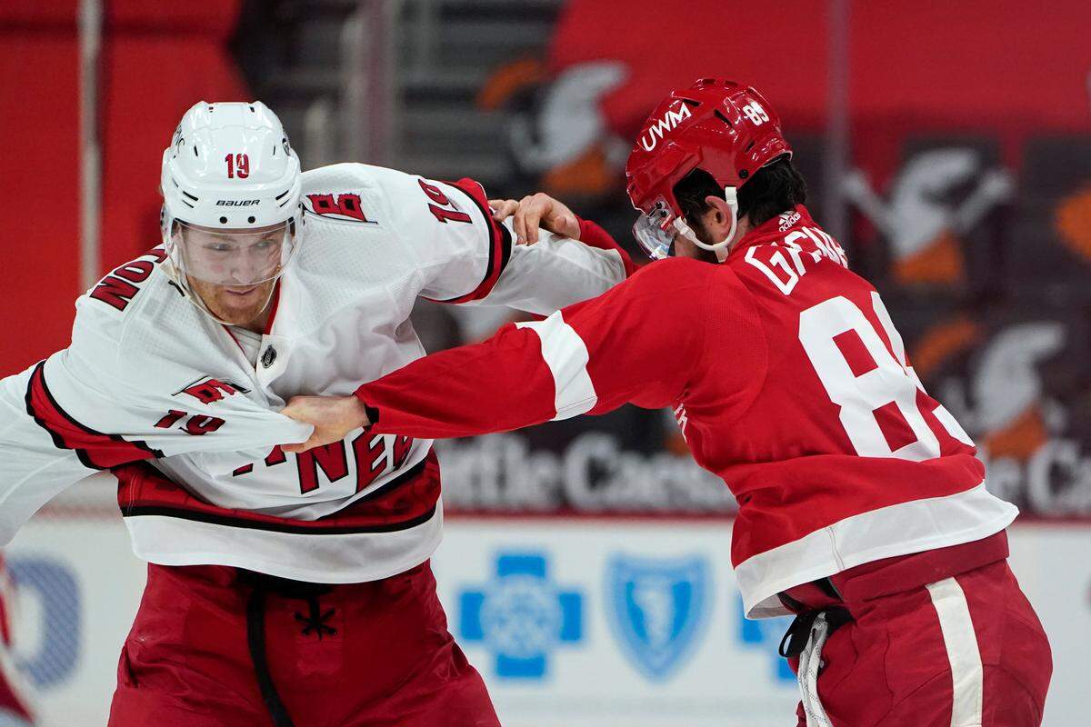 Carolina Hurricanes defenseman Dougie Hamilton (19) and Detroit Red Wings center Sam Gagner (89) fight in the second period of an NHL hockey game Thursday, Jan. 14, 2021, in Detroit. (AP Photo/Paul Sancya)