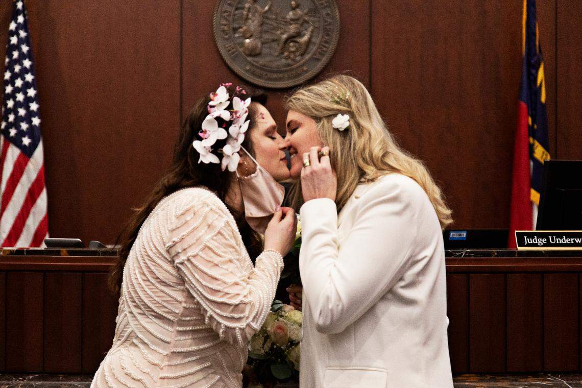 From left, Azul Zapata and Erica Rogers kiss after saying their vows at the Wake County Justice Center in Raleigh on Friday, Feb. 4, 2022. Rogers, who is Canadian, and Zapata, who is Argentinian, were accompanied by their families for the wedding.