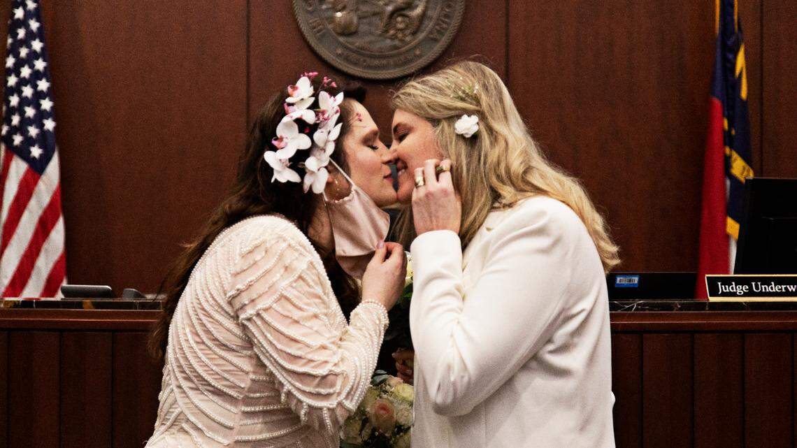 From left, Azul Zapata and Erica Rogers kiss after saying their vows at the Wake County Justice Center in Raleigh on Friday, Feb. 4, 2022. Rogers, who is Canadian, and Zapata, who is Argentinian, were accompanied by their families for the wedding.