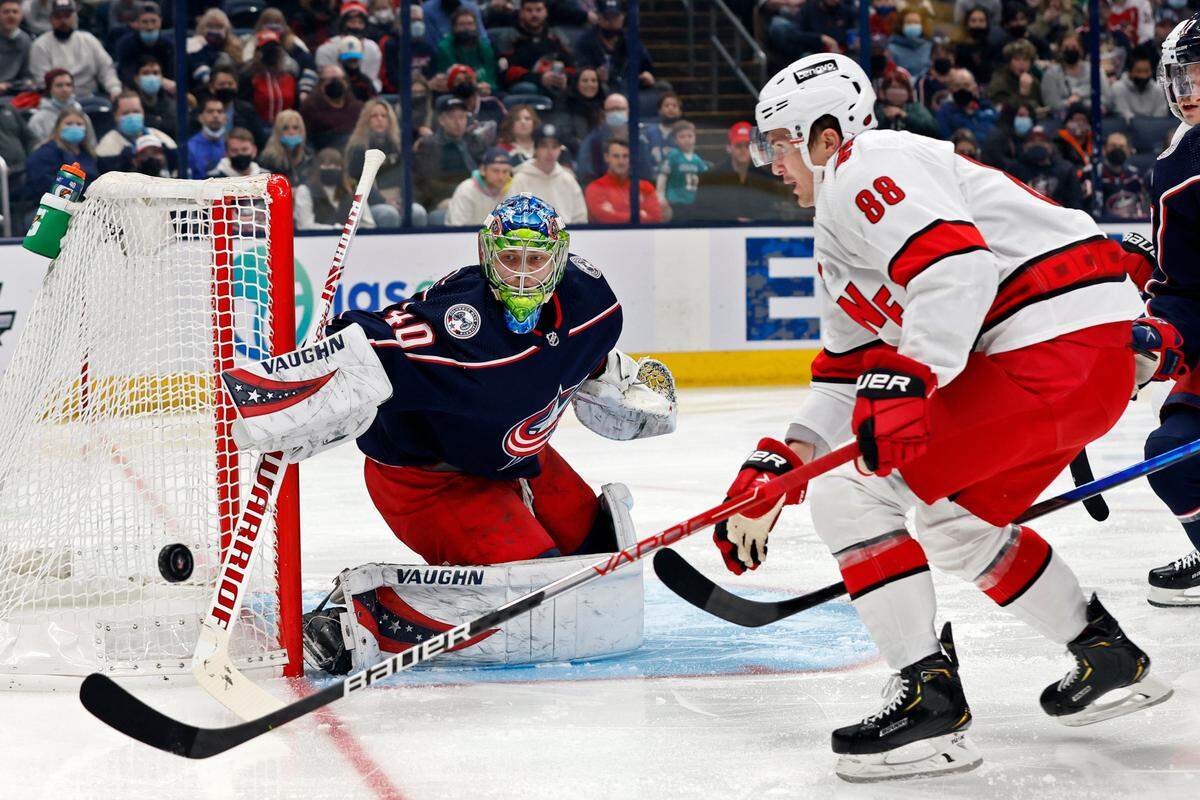 Columbus Blue Jackets’ Daniil Tarasov, left, makes a save against Carolina Hurricanes’ Martin Necas during the first period of an NHL hockey game Saturday, Jan. 1, 2022, in Columbus, Ohio. (AP Photo/Jay LaPrete)