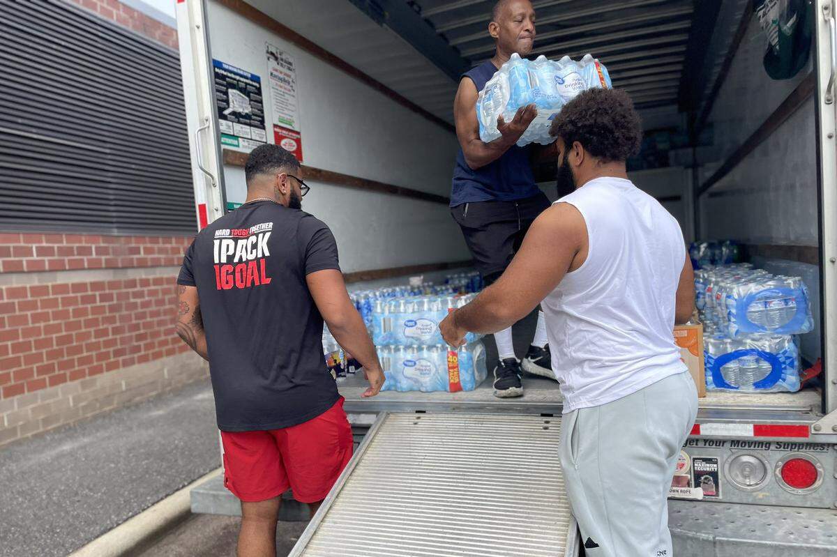 N.C. State defensive end Davin Vann, left, and his brother Rylan, an offensive lineman, help collect supplies at Close-King Indoor Practice Facility Monday, Sept. 30, 2024. The Vanns are working with their mother Joy Hall-Haley to collect supplies that will be transported to residents in western North Carolina.