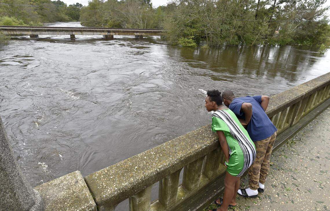 Taquana Sanders and George Green, of Fayetteville, NC,watch the rising waters of the Lumber River in Lumberton, NC Sunday morning. Heavy rains from Tropical Storm Florence are causing widespread flooding in the area, and water levels are expected to rise dramatically as the storm continues to dump more rain on much of North Carolina.