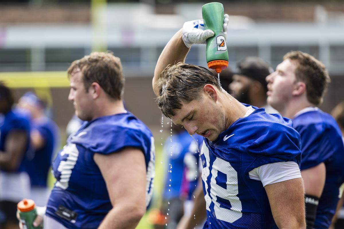 Duke’s Paxon Kettering cools down during a break in football practice as temperatures climbed into the 90s on Monday, July 28, 2025.
