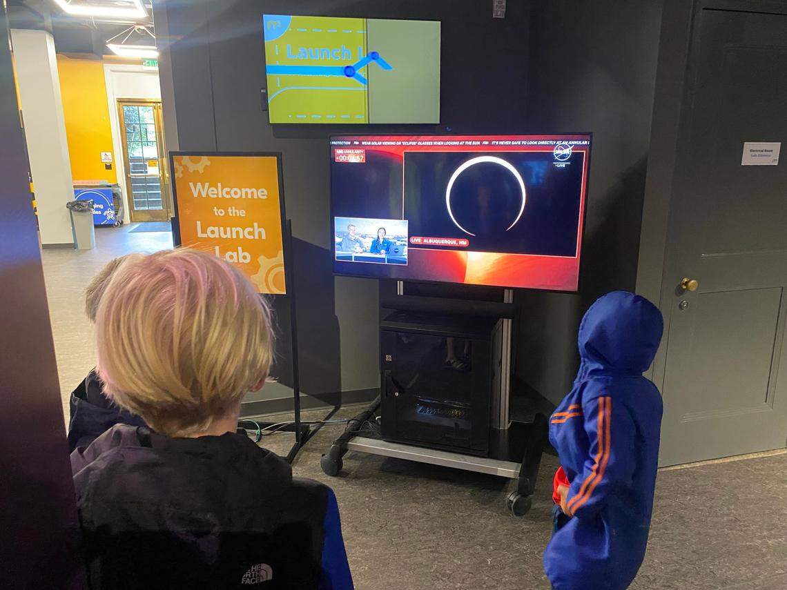 Children watch a live stream of an annular eclipse over New Mexico from the Morehead Planetarium and Science Center.
