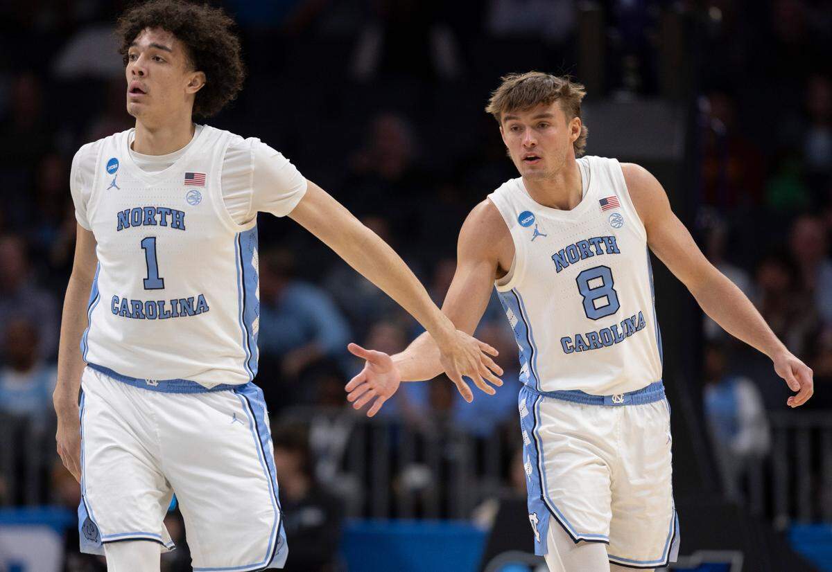 North Carolina’s Paxson Wojcik (8) is congratulated by teammate Zayden High (1) after sinking a three-point basket to give the Tar Heels a 88-58 lead in the second half on Thursday, March 21, 2024 during the NCAA Tournament at Spectrum Center in Charlotte, N.C.