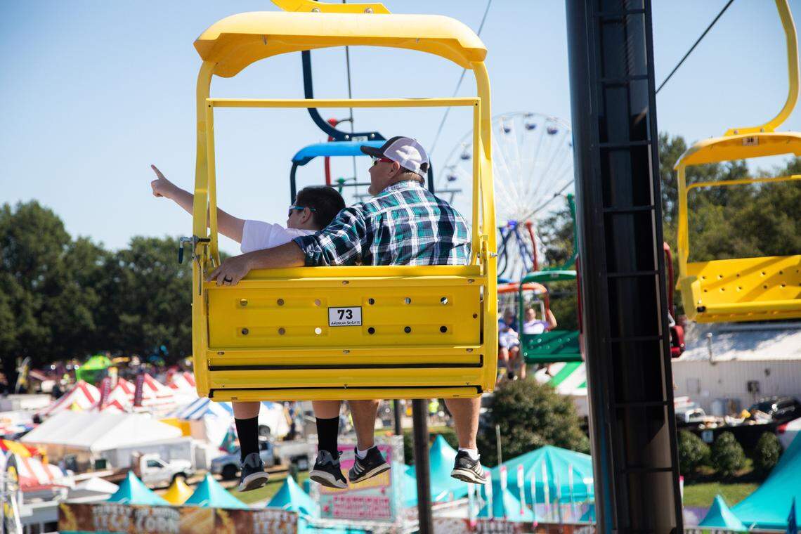 Shawn Rychcik and his son Ajay, 11, of Apex ride the State Fair Flyer on opening day of the NC State Fair Friday, Oct. 12, 2018 after Thursday’s opening day was cancelled due to weather associated with Hurricane Michael.