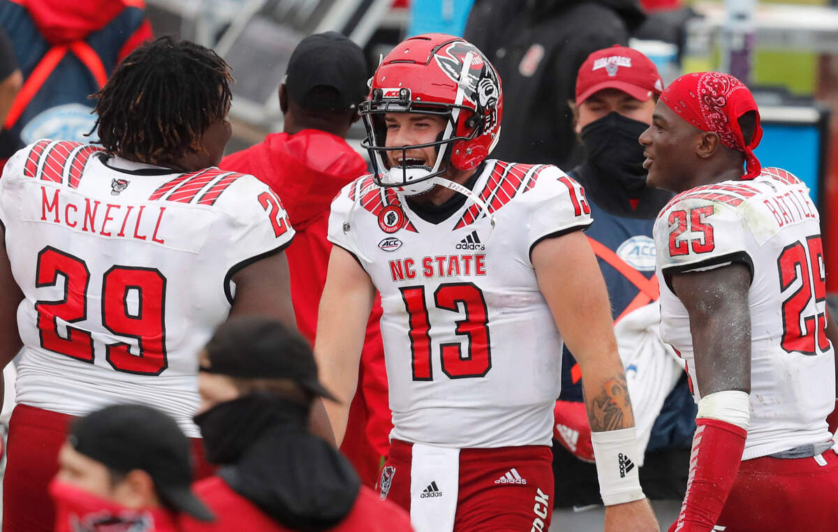N.C. State quarterback Devin Leary (13) laughs with defensive tackle Alim McNeill (29) and cornerback Shyheim Battle (25) late in the second half of N.C. State’s 38-21 victory over Virginia at Scott Stadium in Charlottesville, Va., Saturday, Oct. 10, 2020.